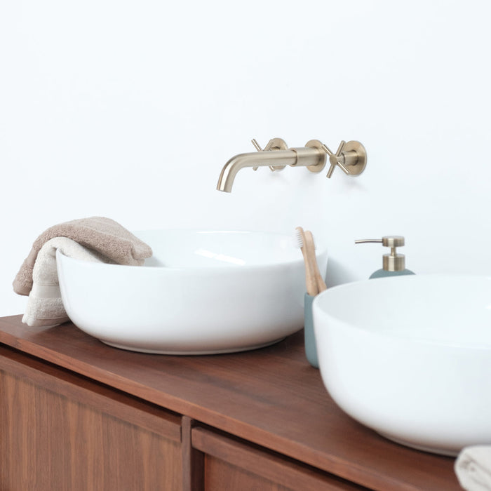 Gouden kranen, witte lavabo's, bruine vintage kast