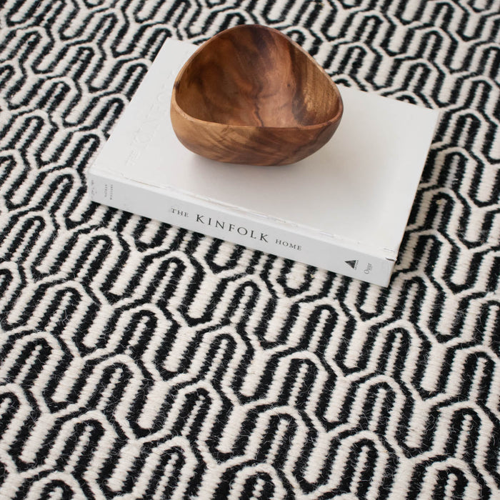 zwart wit helder tapijt Furnified dichtbij met een boek en schaal.ALT